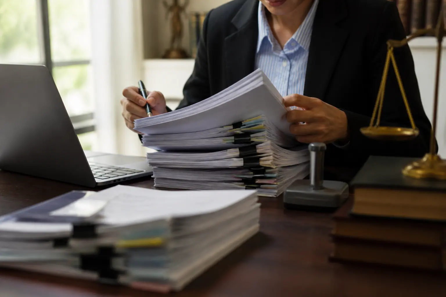Professionnel relisant un dossier de contrat ccag fcs, documents administratifs empilés, ambiance conformité et contrôle