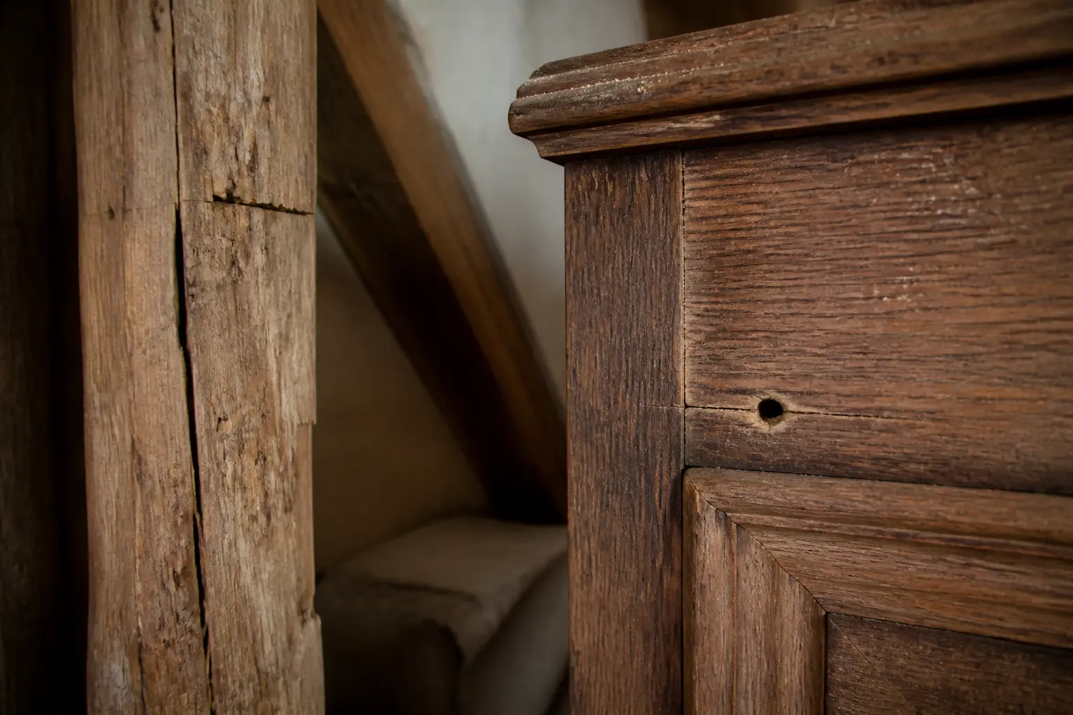 Diagnostic de mites bois sur poutre et meuble ancien, vermoulure visible et petit trou de sortie en intérieur